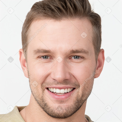 Joyful white young-adult male with short  brown hair and grey eyes