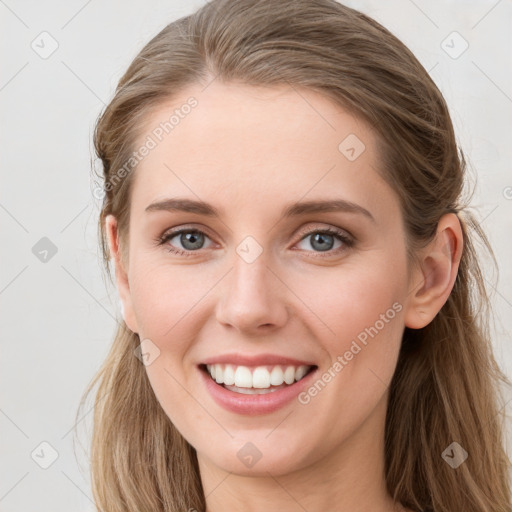 Joyful white young-adult female with long  brown hair and blue eyes