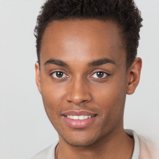 Joyful black young-adult male with short  brown hair and brown eyes