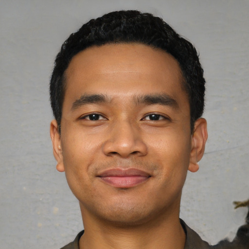 Joyful latino young-adult male with short  black hair and brown eyes