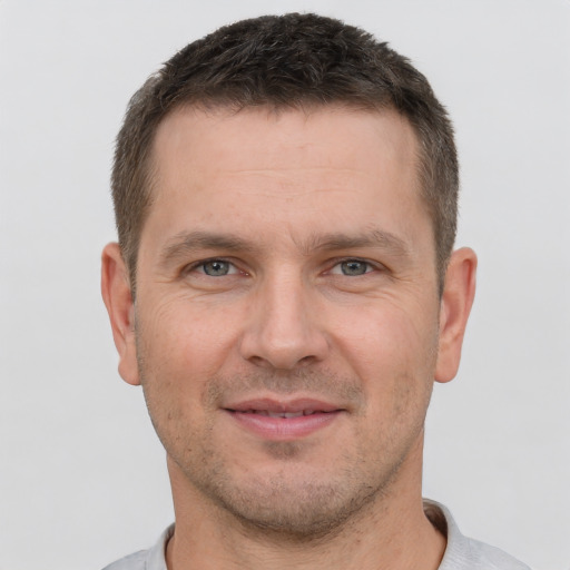 Joyful white adult male with short  brown hair and brown eyes