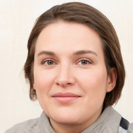 Joyful white young-adult female with medium  brown hair and blue eyes