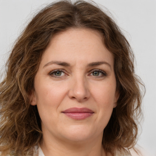 Joyful white young-adult female with medium  brown hair and green eyes