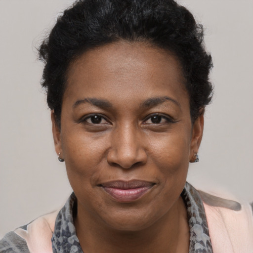 Joyful black young-adult female with short  black hair and brown eyes