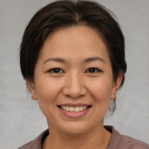 Joyful asian young-adult female with medium  brown hair and brown eyes