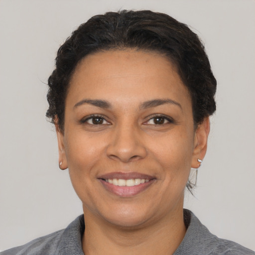 Joyful latino adult female with short  black hair and brown eyes