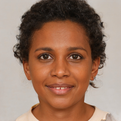 Joyful black young-adult female with short  brown hair and brown eyes