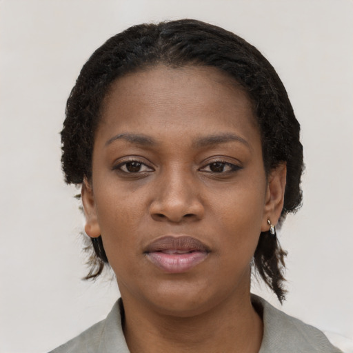 Joyful black young-adult female with short  black hair and brown eyes