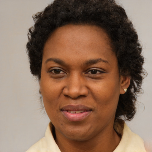 Joyful black adult female with medium  brown hair and brown eyes