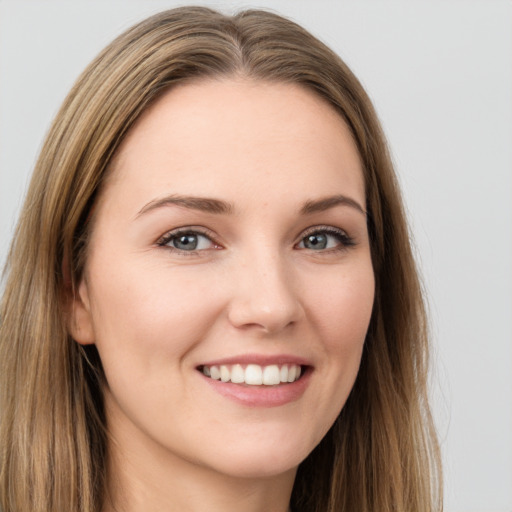 Joyful white young-adult female with long  brown hair and grey eyes