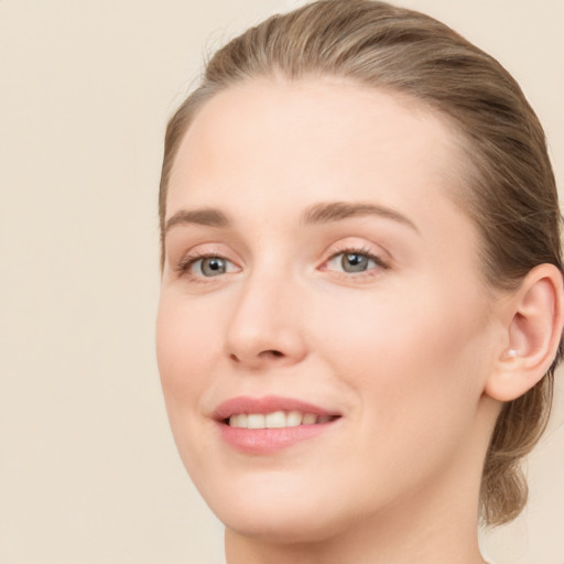 Joyful white young-adult female with long  brown hair and blue eyes