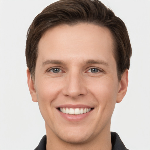 Joyful white young-adult male with short  brown hair and grey eyes