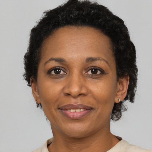 Joyful black adult female with short  brown hair and brown eyes