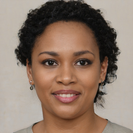 Joyful black young-adult female with short  brown hair and brown eyes