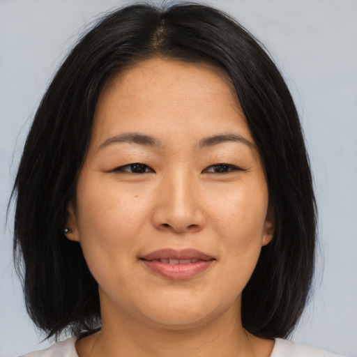 Joyful asian adult female with medium  brown hair and brown eyes