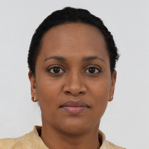 Joyful black young-adult female with short  brown hair and brown eyes