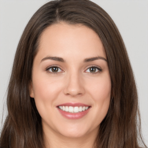 Joyful white young-adult female with long  brown hair and brown eyes