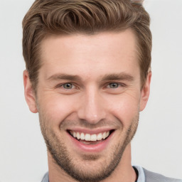 Joyful white young-adult male with short  brown hair and grey eyes