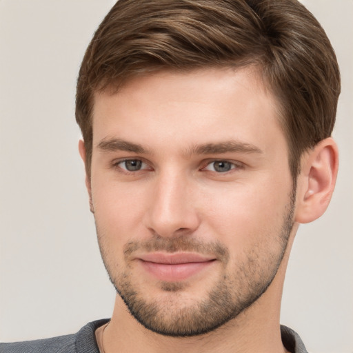 Joyful white young-adult male with short  brown hair and grey eyes