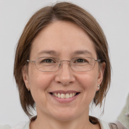 Joyful white adult female with medium  brown hair and grey eyes