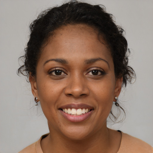 Joyful black young-adult female with medium  brown hair and brown eyes