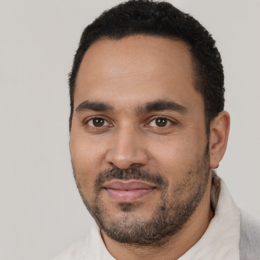 Joyful black young-adult male with short  black hair and brown eyes