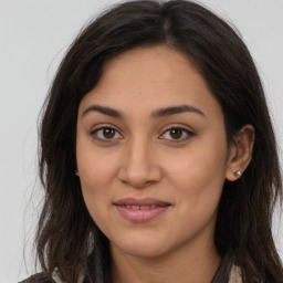 Joyful latino young-adult female with long  brown hair and brown eyes