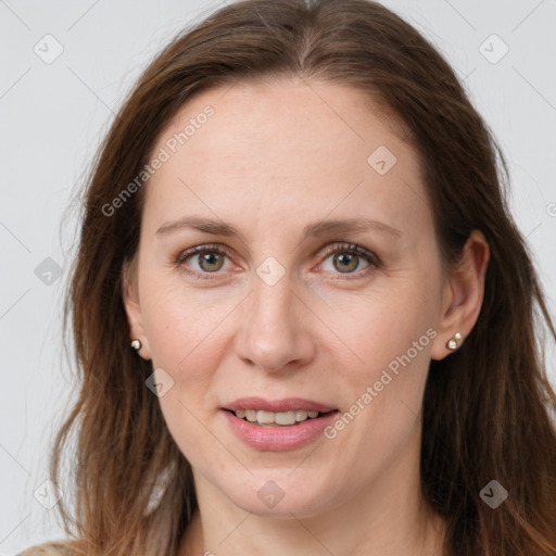 Joyful white adult female with long  brown hair and grey eyes