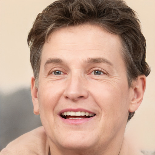 Joyful white adult male with short  brown hair and grey eyes