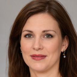 Joyful white young-adult female with long  brown hair and green eyes