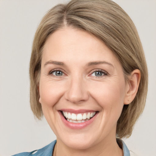 Joyful white adult female with medium  brown hair and grey eyes