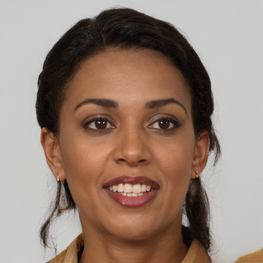 Joyful latino adult female with medium  brown hair and brown eyes