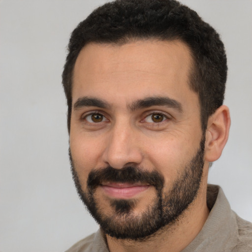 Joyful white young-adult male with short  black hair and brown eyes