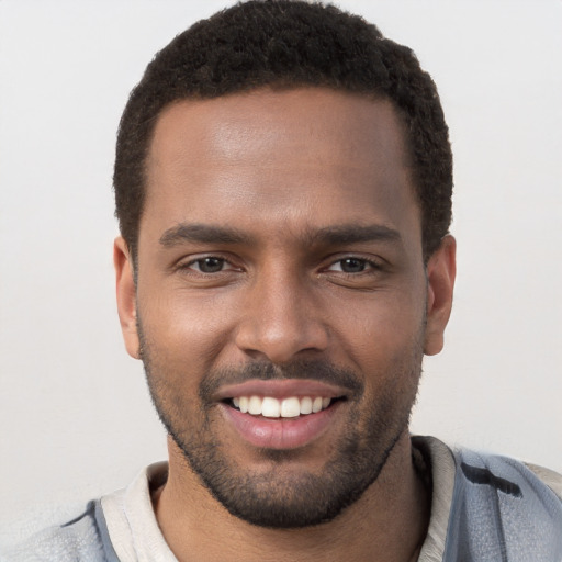 Joyful black young-adult male with short  brown hair and brown eyes