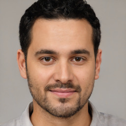 Joyful white young-adult male with short  black hair and brown eyes