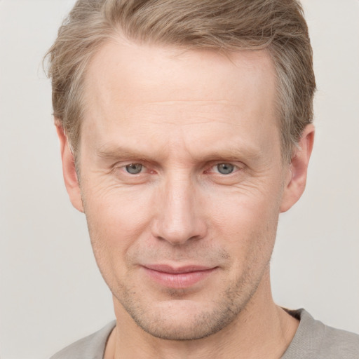 Joyful white adult male with short  brown hair and grey eyes