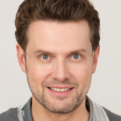 Joyful white adult male with short  brown hair and grey eyes