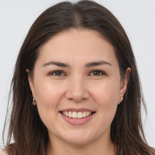 Joyful white young-adult female with long  brown hair and brown eyes