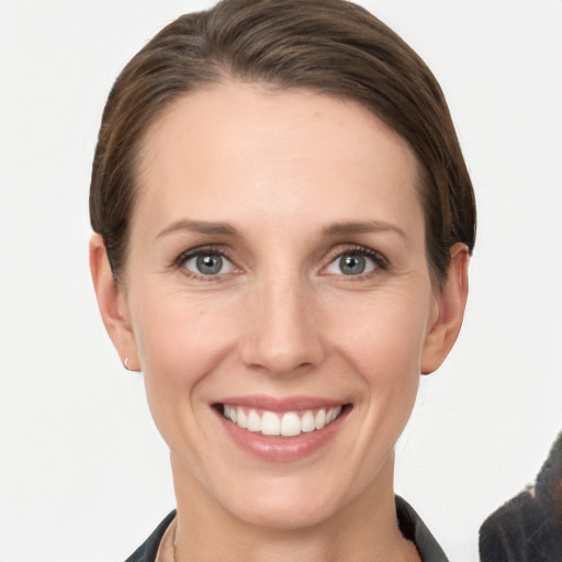 Joyful white young-adult female with short  brown hair and grey eyes