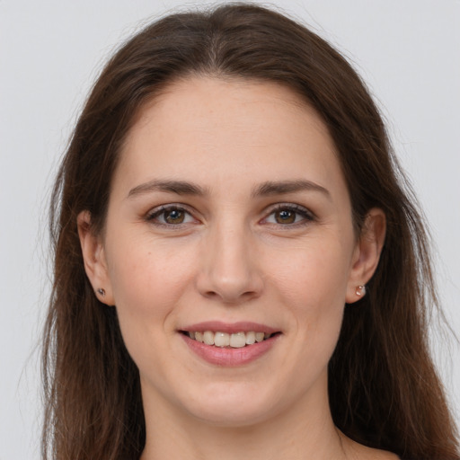 Joyful white young-adult female with long  brown hair and brown eyes