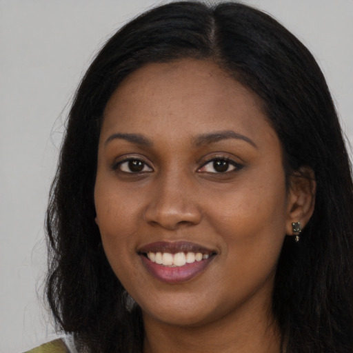 Joyful black young-adult female with long  black hair and brown eyes