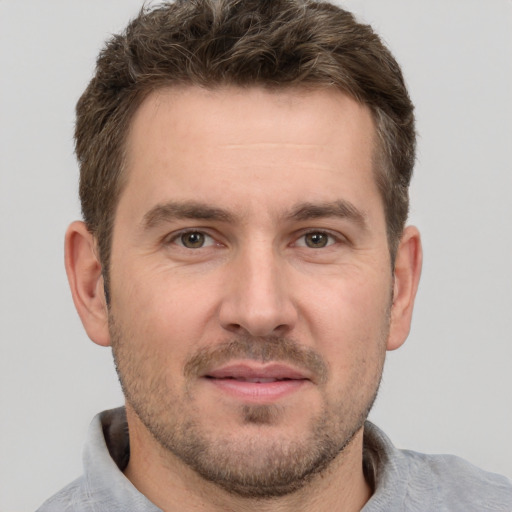 Joyful white adult male with short  brown hair and grey eyes