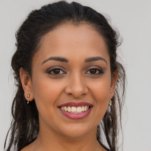 Joyful latino young-adult female with long  brown hair and brown eyes