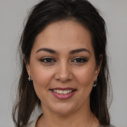 Joyful latino young-adult female with medium  brown hair and brown eyes