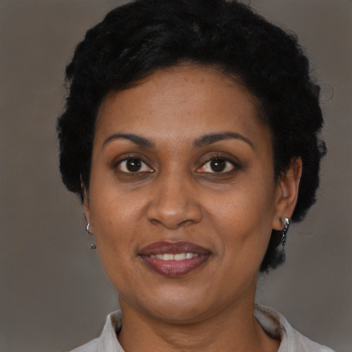 Joyful black adult female with short  black hair and brown eyes