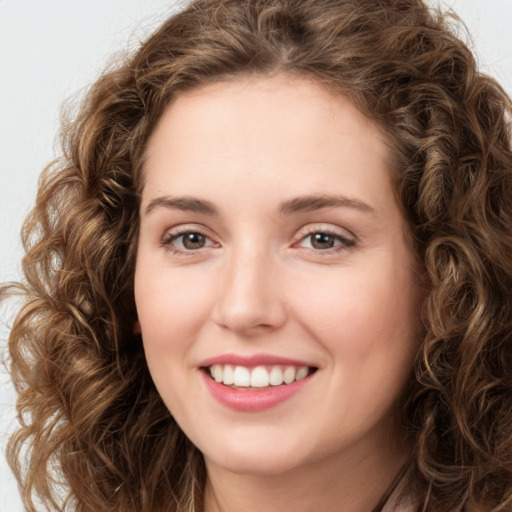 Joyful white young-adult female with long  brown hair and green eyes