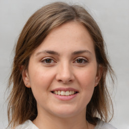 Joyful white young-adult female with medium  brown hair and grey eyes