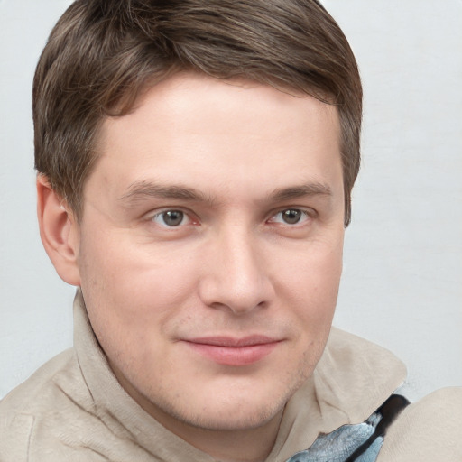 Joyful white young-adult male with short  brown hair and grey eyes