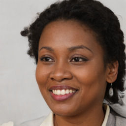 Joyful black young-adult female with long  brown hair and brown eyes