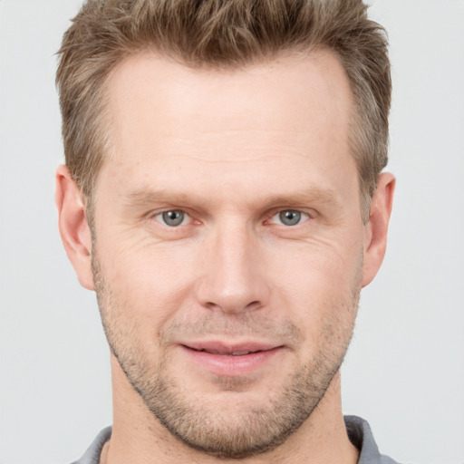 Joyful white adult male with short  brown hair and grey eyes